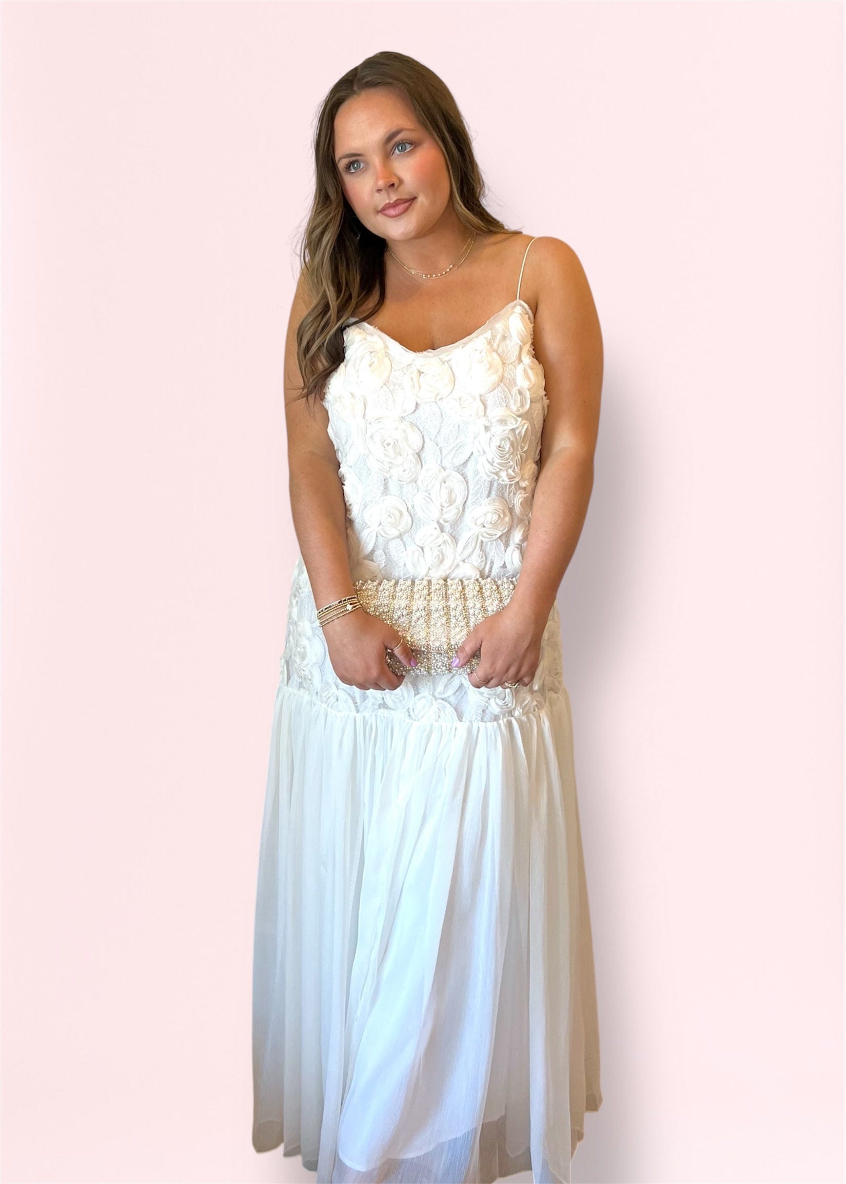 Elegant front view of model in long white lace floral maxi dress with adjustable straps and sheer hem.