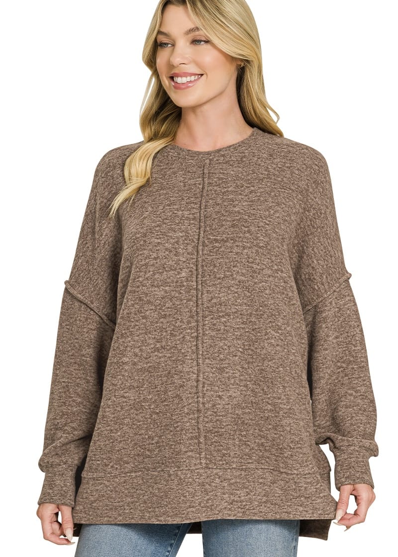 Woman wearing mocha oversized sweater with exposed seams and relaxed fit