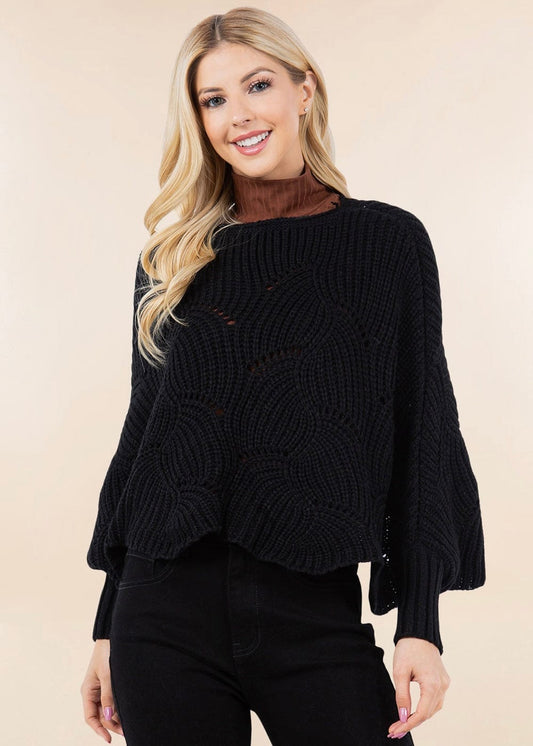 Woman wearing a black sweater against a beige background