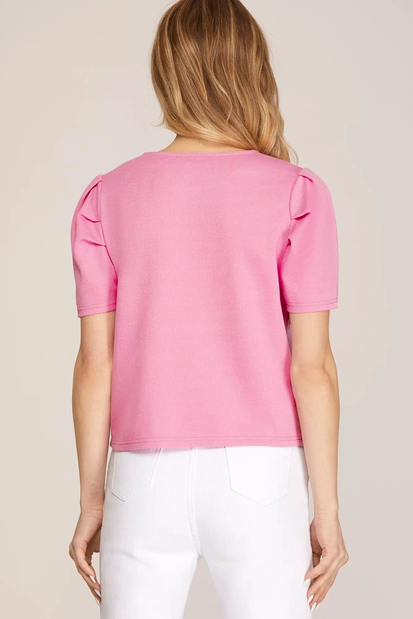 Back view of pink puff sleeve top with clean hem and structured sleeves