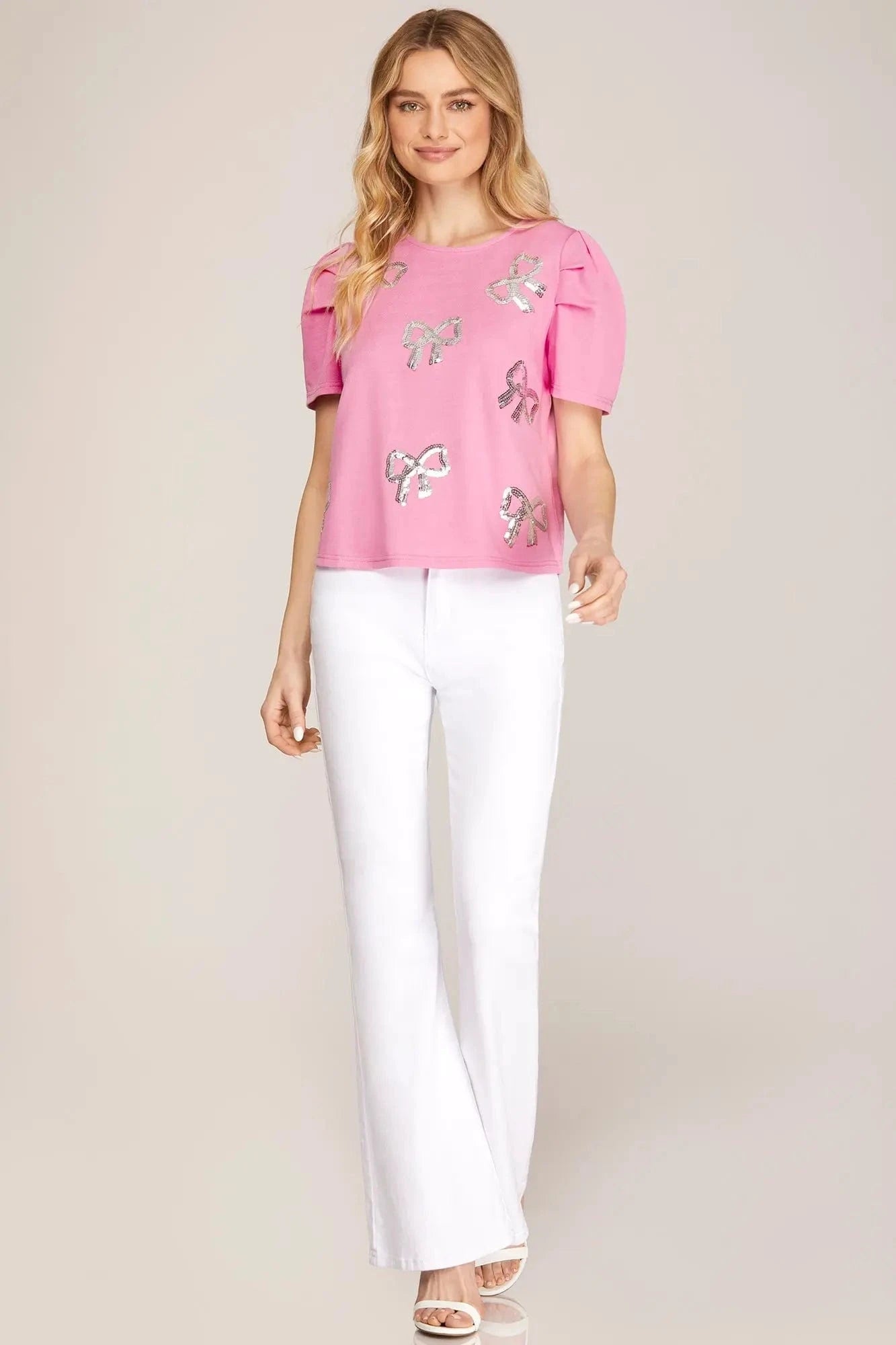 Model wearing Barbie pink puff sleeve top with white denim for a boutique look