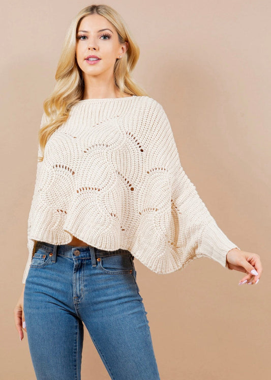 Model wearing one size cream cape sweater with batwing sleeves