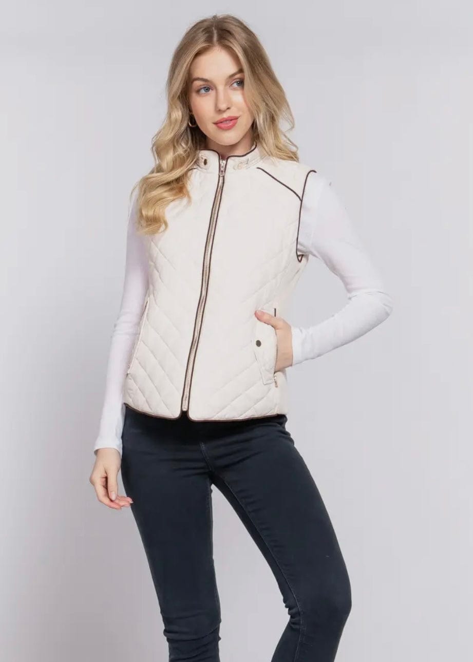 Cream quilted vest styled for fall with leather pants