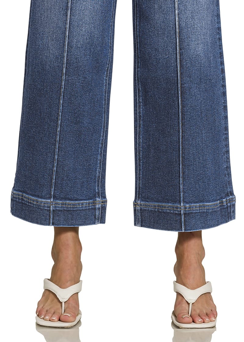 Close-up of wide hem and front seam detail on dark wash wide leg jeans