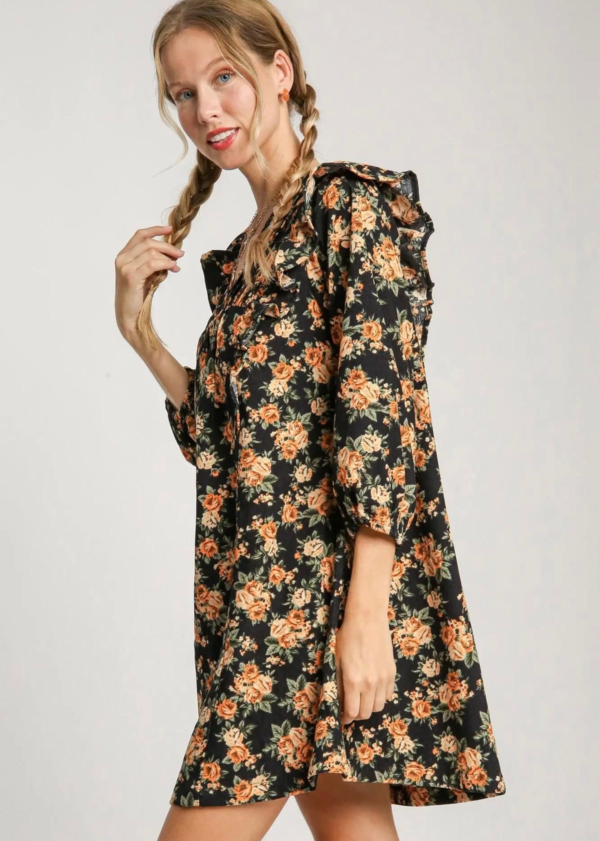 Side view of black floral mini dress with three-quarter sleeves and ruffle details