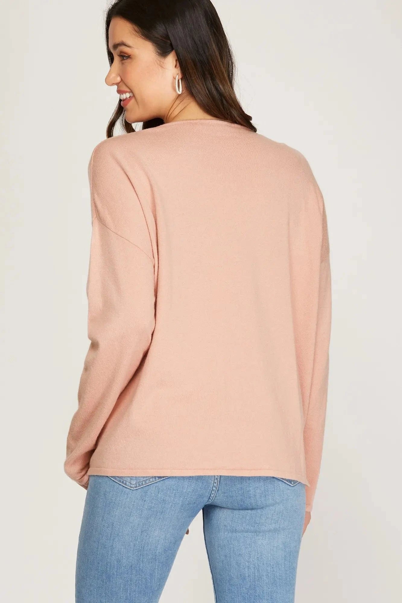 Back view of relaxed-fit pink sweater with drop shoulder design.