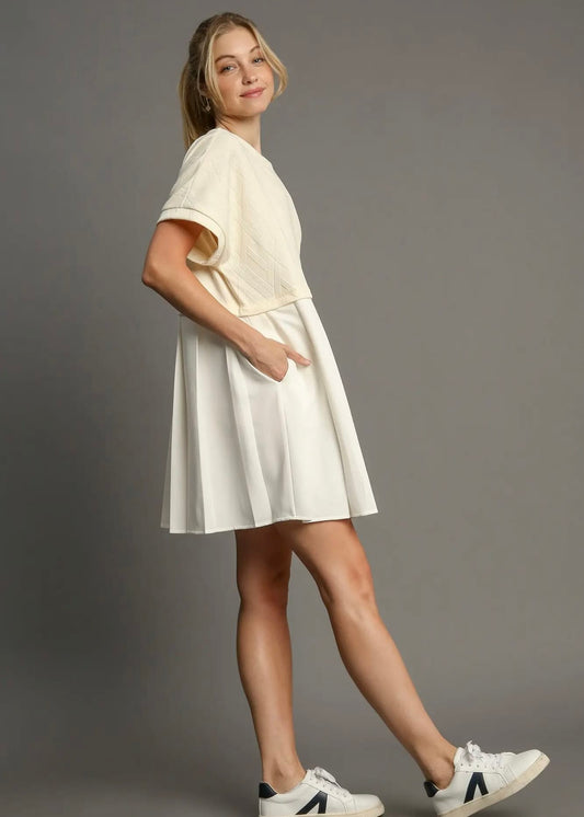 Side view of ivory relaxed-fit mini dress styled with sneakers