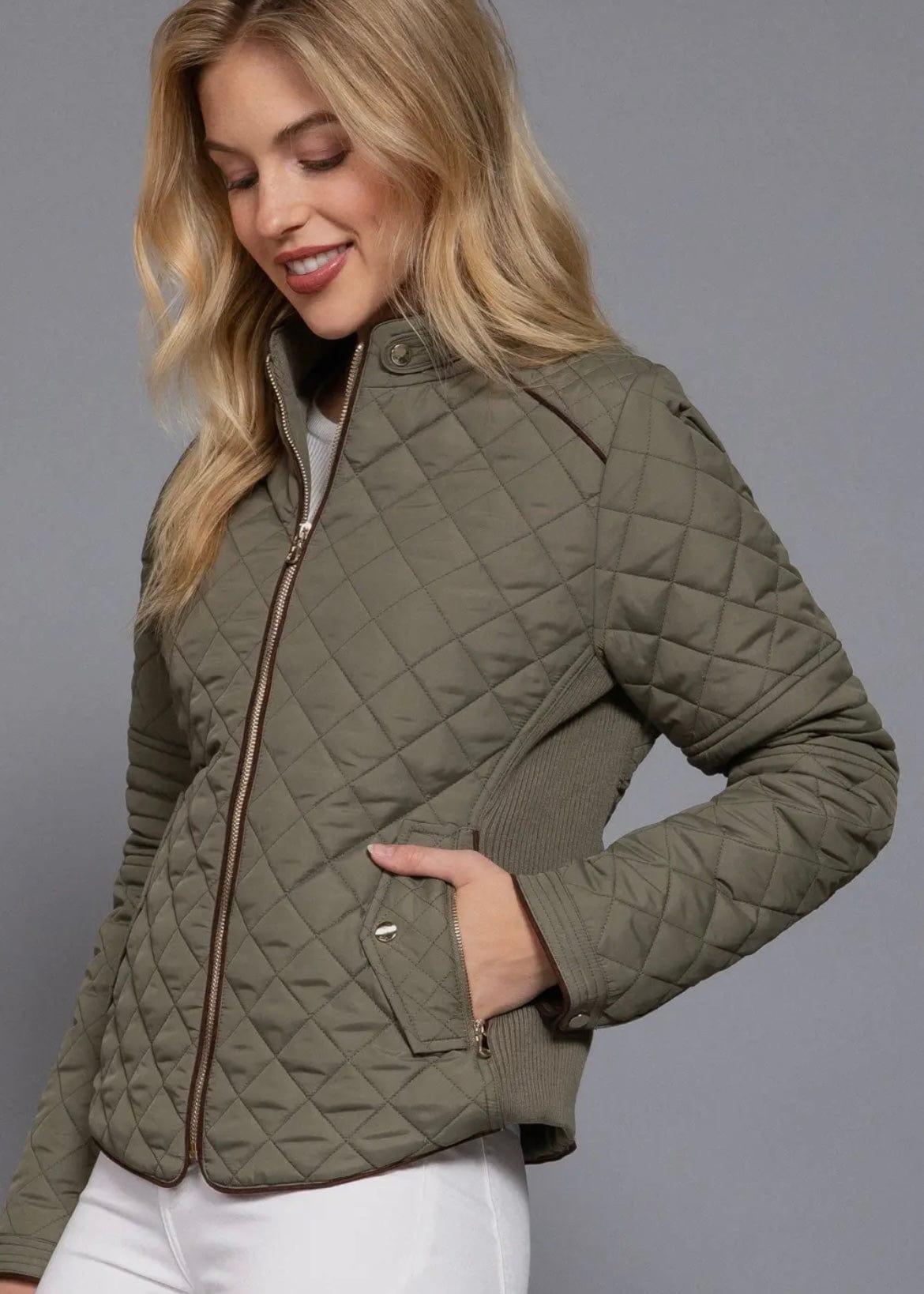 Side angle showing curved hem and structured fit of olive jacket
