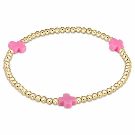 Close-up image of the enewton Signature Cross Bracelet featuring 3mm 14kt gold-filled round beads and three evenly spaced bright pink cross-shaped accents, displayed in a circular shape on a clean white background. The bracelet is strung on high-performance elastic for a comfortable, stretch fit, highlighting its minimalist yet meaningful design ideal for stacking and everyday wear.