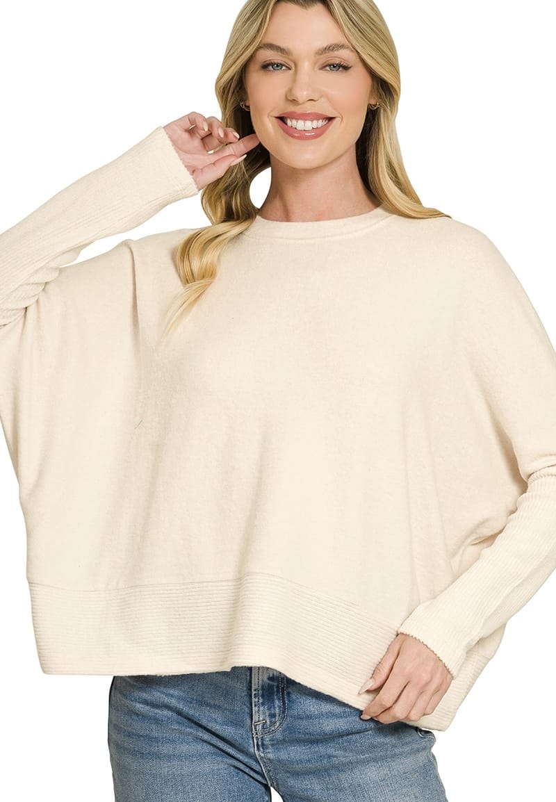 Woman modeling cream oversized knit sweater with ribbed cuffs and hem